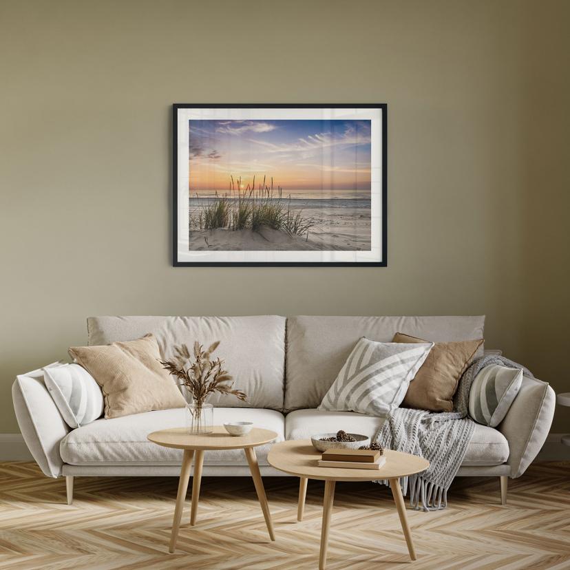 Poster sanddyn på stranden vid solnedgången