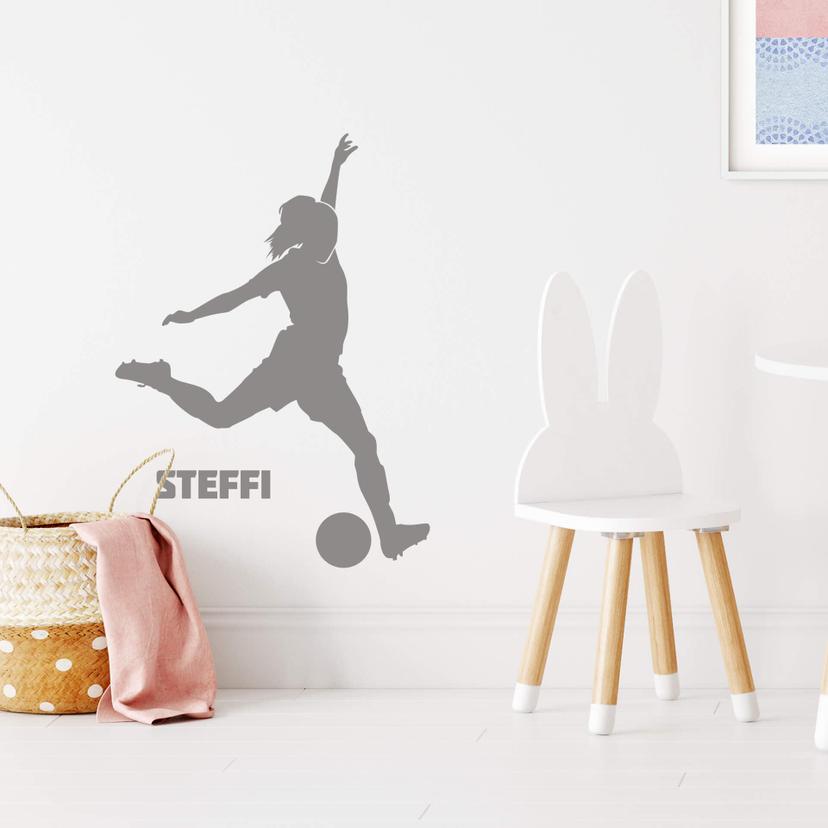 Sticker mural joueuse de football qui tire à personnaliser