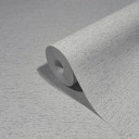 Non-woven tapet i et let meleret look som almindeligt gråt tapet med klister på væggen