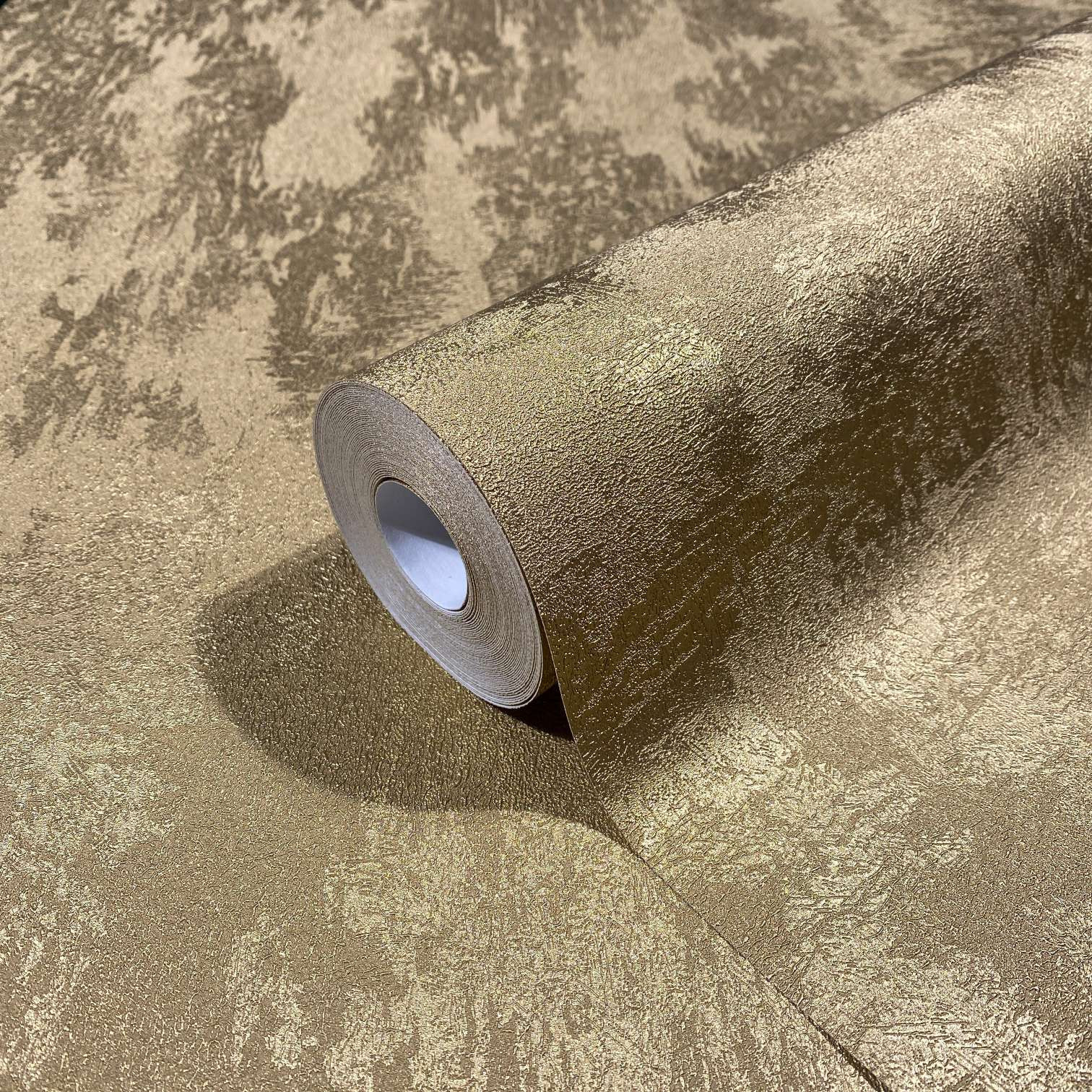 Non-woven tapet med en stark glanseffekt i en ljus guldstruktur med betonglook